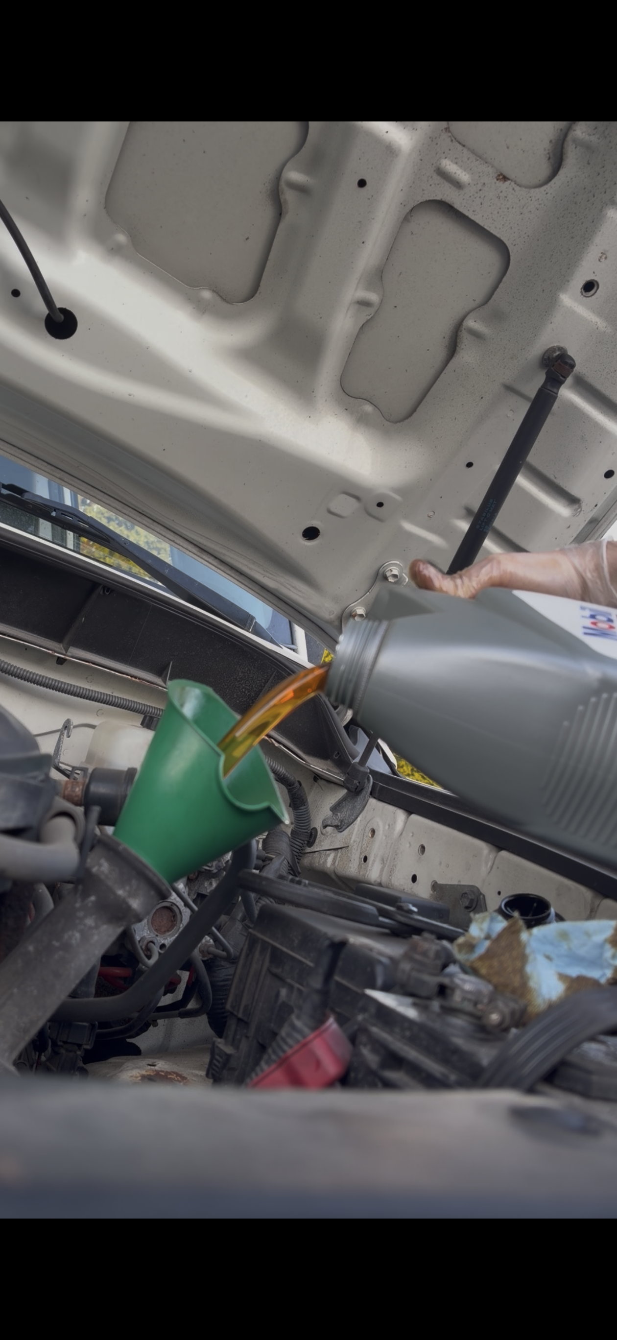 Fresh oil being poured during a mobile oil change